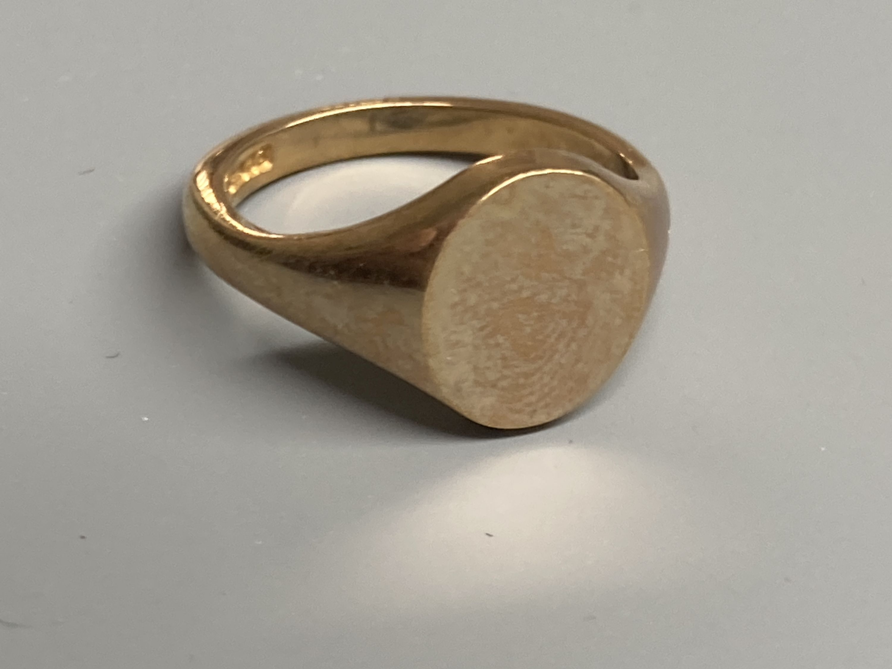 Four assorted modern 9ct gold signet rings and one other similar 9ct ring, largest size V